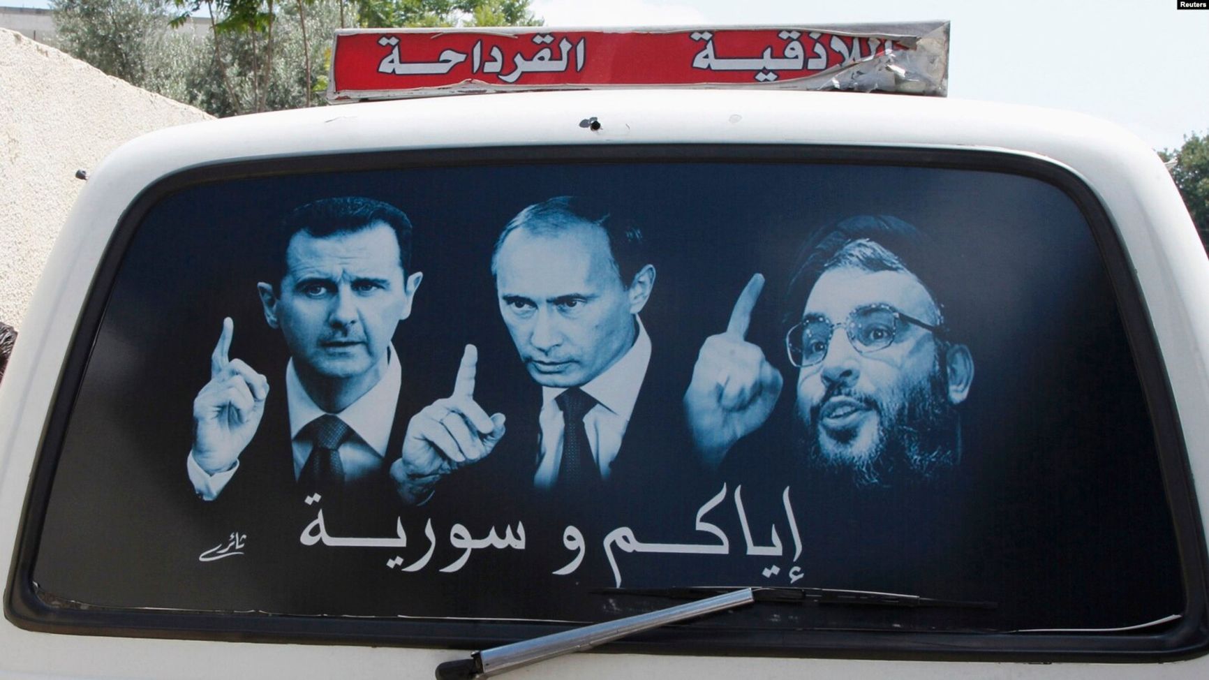 The decal on the car window depicts Syrian President Bashar al-Assad, Russian President Vladimir Putin, and Hezbollah leader Sayyed Hassan Nasrallah. Latakia, Syria, May 2014.