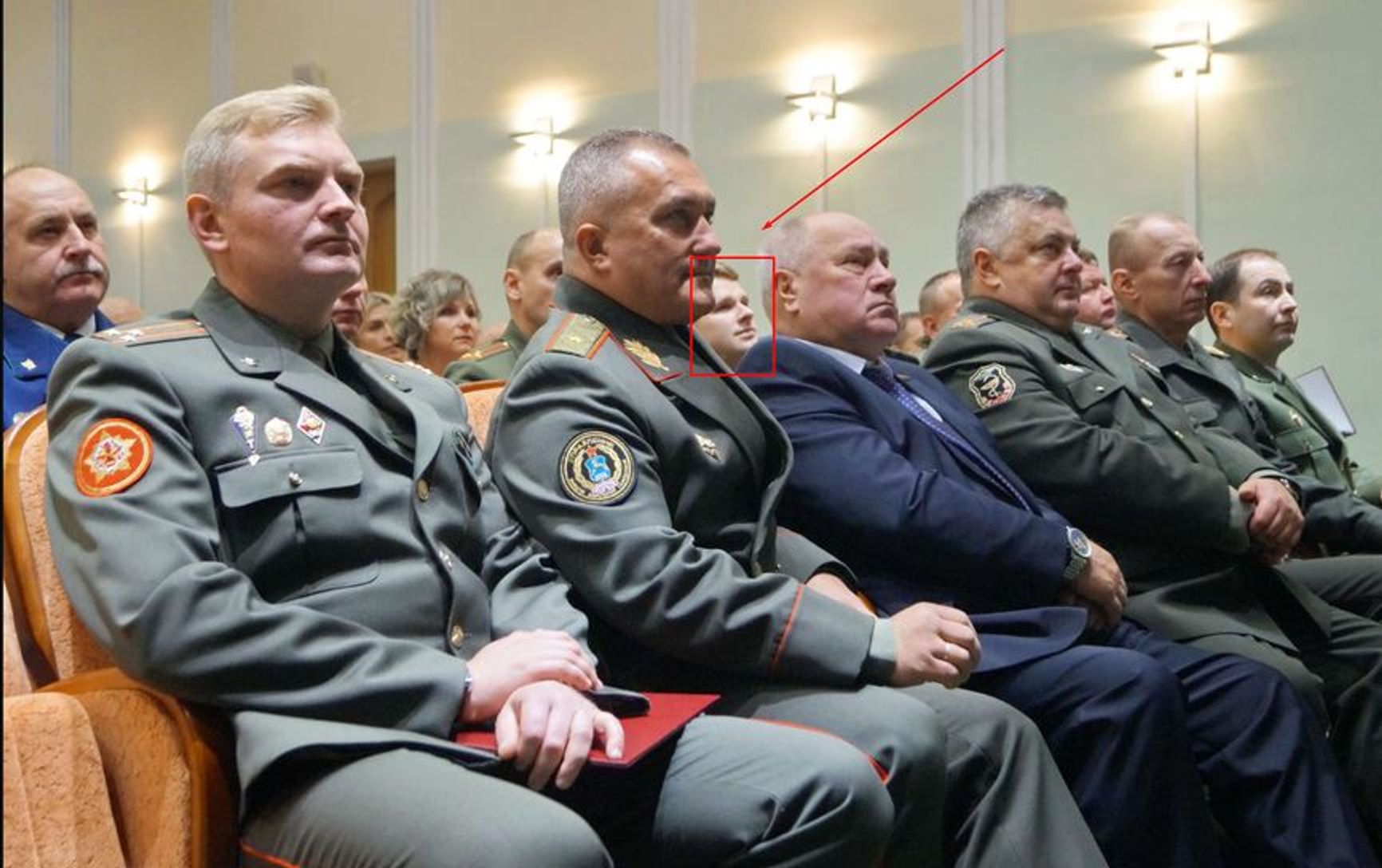 Aleksei Lobeev peeks out from behind the chin of GRU head Ruslan Kosygin