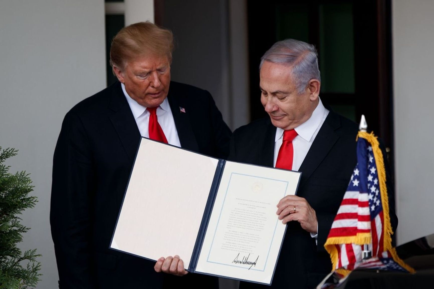 Donald Trump and Israeli Prime Minister Benjamin Netanyahu display the signed peace plan